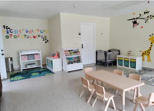 Learning corner with alphabet wall display, bookshelves, and child-sized tables